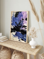 Abstract art print with dynamic blue, purple, and black paint splatters and strokes on a, in an alternate framed mockup