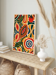 Abstract botanical wall art with stylized leaves and a red tomato in yellow, green, and navy, in an alternate framed mockup