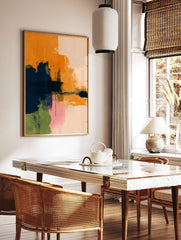 Abstract art print with bold orange, navy blue, pink, and green brushstrokes on a light background, in a styled room mockup