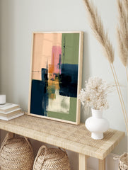 Abstract art print with layered blocks of pink, navy blue, green, and orange with visible, in an alternate framed mockup