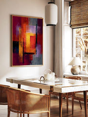 Abstract geometric art print with layered rectangles in red, orange, yellow, and purple tones with, in a styled room mockup