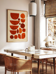Abstract geometric art print with organic shapes in varying shades of orange and red against a, in a styled room mockup