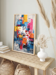 Abstract graffiti wall art with white and yellow spray-painted typography over blue, yellow, in an alternate framed mockup