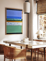 Abstract painting with horizontal bands of blue, green, white, gold, and black with visible, in a styled room mockup