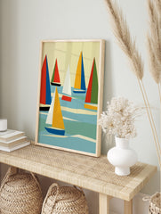 Abstract sailboat wall art with geometric red, blue, and yellow sails on a blue sea against a, in an alternate framed mockup