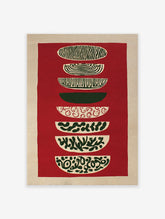 Abstract tapestry wall hanging with stacked red, green, and beige patterned shapes on a textured background.