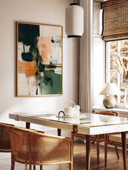 Abstract wall art with dark teal, orange, and off-white colour blocks, dynamic black lines, and, in a styled room mockup