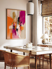 Abstract wall art with dynamic orange, fuchsia, black, and white brushstrokes and delicate lines, in a styled room mockup