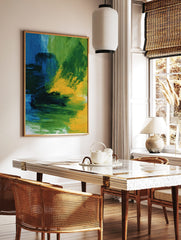 Abstract wall art print with bold blue, green, and yellow painterly brushstrokes and dynamic, in a styled room mockup