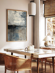 Abstract weathered concrete wall art print with horizontal dark band, off-white, grey, and blue, in a styled room mockup