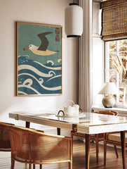 Japanese style albatross flying over blue and white waves with red kanji seal in the corner, in a styled room mockup