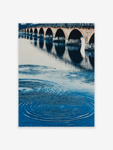 A blue water arch bridge poster featuring a stone bridge with multiple arches reflected in rippling water.