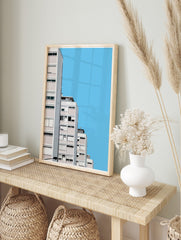 Minimalist architectural wall art of modern white and pink apartment buildings against a clear blue sky, displayed as the same artwork in an alternate framed wall art mockup