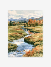 Autumn landscape watercolour painting featuring a winding stream, golden grasses, and orange trees near distant mountains