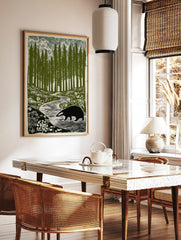 Illustrative print of a badger walking by a winding stream in a forest of tall green trees and, in a styled room mockup