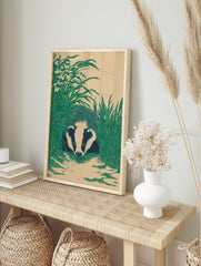 Illustrative badger with striped face peering from green grass and flowers on a beige, in an alternate framed mockup