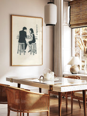 Illustrative print of a man and woman talking at a bar counter with glasses and Japanese text, in a styled room mockup