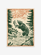 Vintage illustration of a bear catching a fish in a river with pine trees and mountains. Bear fishing art print.