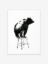 Monochrome illustrative art print of a bear sitting on a wooden stool against a plain white background