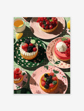 Illustrative food wall art print showing multiple berry tarts, a drink, and a lemon slice on a green checkered tablecloth.