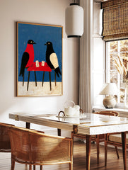 Illustrative art print of two birds playing cards at a red table against a blue background, in a styled room mockup