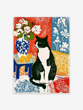 Black and white cat sitting beside blue and white vase with flowers and yellow fruit on patterned background art print