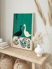 Illustrative print of black and white ducks with a blue patterned teapot and Japanese, in an alternate framed mockup