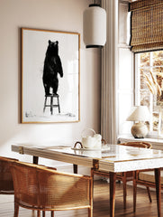 Black bear illustration standing on a wooden stool, monochrome art print on white background, in a styled room mockup