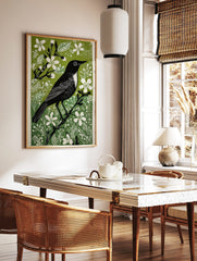 Black bird with white chest on a branch, surrounded by white flowers and green leaves, in a linocut, in a styled room mockup