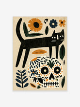 Black cat standing on a floral patterned skull with orange and blue botanical elements on a beige background