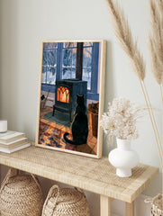 Black cat sitting in front of a glowing cast-iron wood stove with a snowy winter garden, in an alternate framed mockup