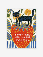 Black cat with blue stripes on a red strawberry with text Trust The Seeds You Are Planting, colourful poster