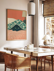 Illustrative print of a black cat with green eyes peeking from under a green palm leaf patterned, in a styled room mockup