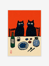Illustrative print of two black cats at a dinner table with fish, sake, and a vase, against an orange background