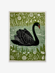Black swan linocut print with green botanical background and white water ripples, facing left
