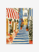 Blue and white striped steps in a Mediterranean village alley with cafe tables, red awning, and potted plants