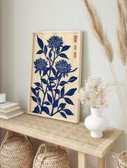 Blue chrysanthemum flower woodblock art print with leaves on a cream background, portrait, in an alternate framed mockup