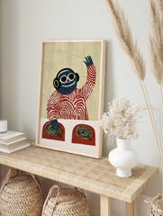 Blue DJ monkey wearing headphones and sunglasses at a turntable, illustrative graphic art, in an alternate framed mockup