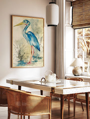 Blue heron bird illustration wall art in watercolour and ink with a yellow beak and pink legs, in a styled room mockup