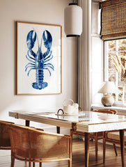 Blue lobster watercolour illustration art print with large claws on a white plank background, in a styled room mockup