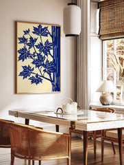 Illustrative blue maple leaves and tree trunk art print on a cream background, portrait orientation, in a styled room mockup