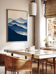 Minimalist blue mountain landscape wall art print with layered peaks and misty atmospheric effect, in a styled room mockup