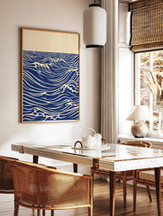 Stylised blue ocean waves with white crests and horizon line on an unframed paper print, in a styled room mockup