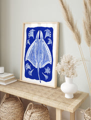 Ornate blue and white stingray illustration with decorative fan-like elements on a deep blue, in an alternate framed mockup
