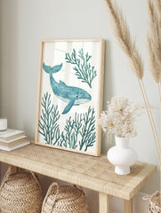 Blue whale with stippled texture swimming amidst teal coral branches on a white background, in an alternate framed mockup
