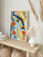 Blue whale swimming among stylized yellow and orange seaweed, modern illustrative ocean art, in an alternate framed mockup