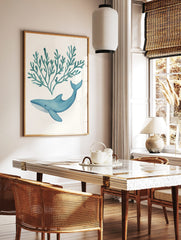 Blue watercolour whale swimming below teal seaweed illustration on white background, in a styled room mockup