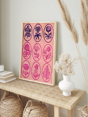Vintage-style grid of nine botanical flower illustrations in oval frames on a pink, in an alternate framed mockup