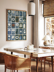 Grid artwork with cats, flowers, pottery, and celestial symbols in blue, white, and brown on a, in a styled room mockup