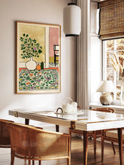 Botanical interior scene wall art print with a white vase of green and purple flowers, orange and green bottles, and a floral patterned rug. - Image 2